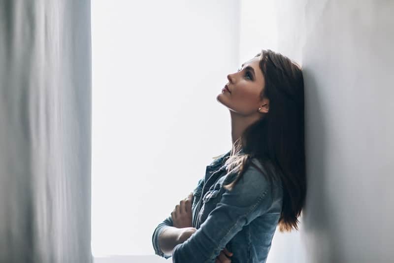 mujer preocupada junto a la pared