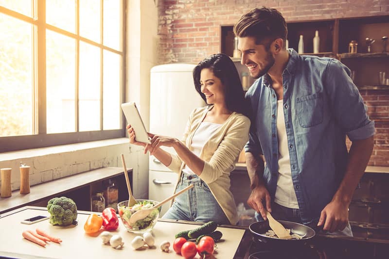 giovane coppia che cucina in cucina