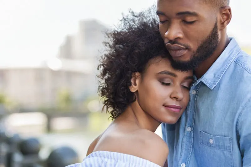 young couple hugging with closed eyes