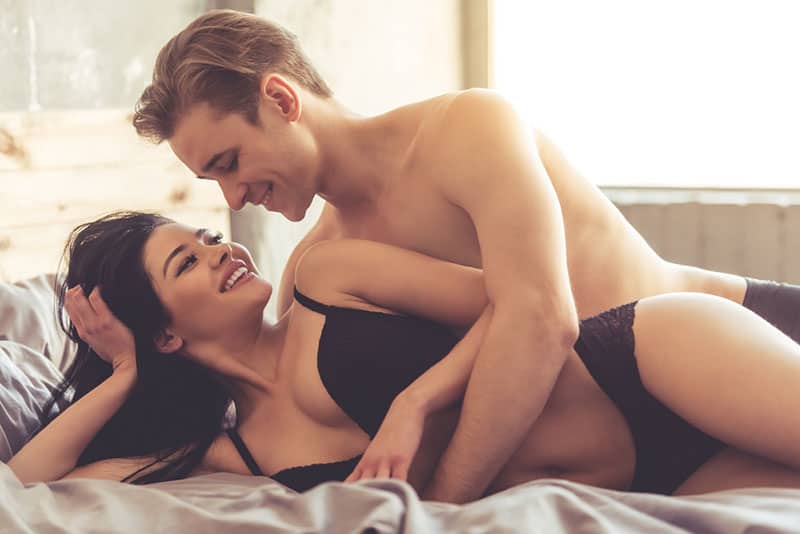 young couple smiling on bed