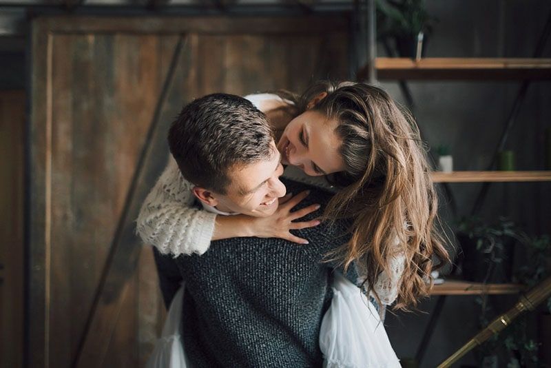 mulher jovem abraçando homem sorridente