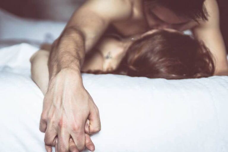 passionate couple kissing in bed