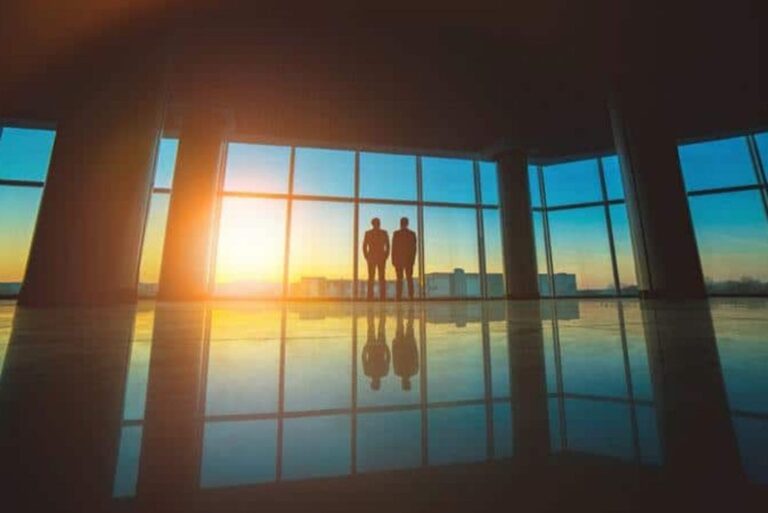 two men stand by the window