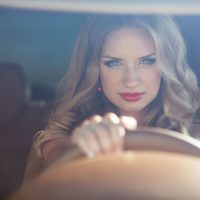 confident beautiful blond woman riding car