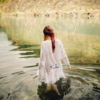 a woman in a white dress tramples the river