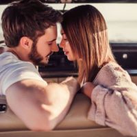 couple hugging and kissing while being in car.