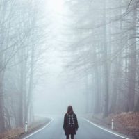 a woman stands on the street with her back turned