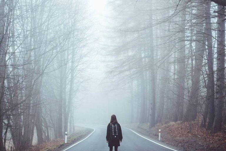 a woman stands on the street with her back turned