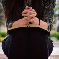 mujer sosteniendo la biblia sobre sus piernas