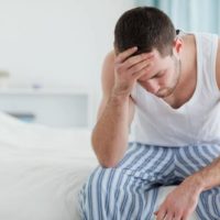 worried man sitting on bed