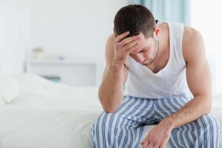 worried man sitting on bed