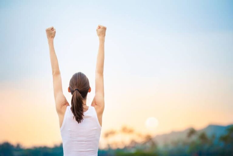 strong woman raising arms to the sky