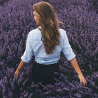 back view of woman standing on purple field