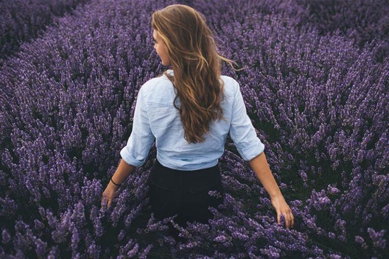 back view of woman standing on purple field