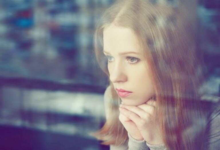 sad woman looking through window