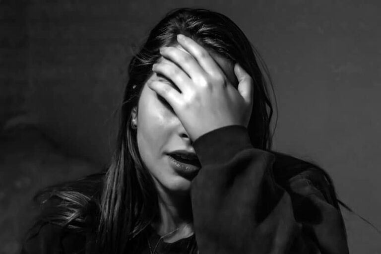 mujer triste con la mano en la cara