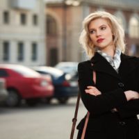 a woman with short blonde hair stands on the street