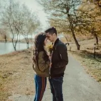 romantic couple standing face to face near lake