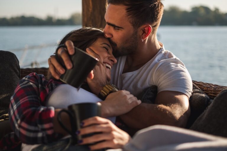 a man who hugs his wife and kisses her on the forehead