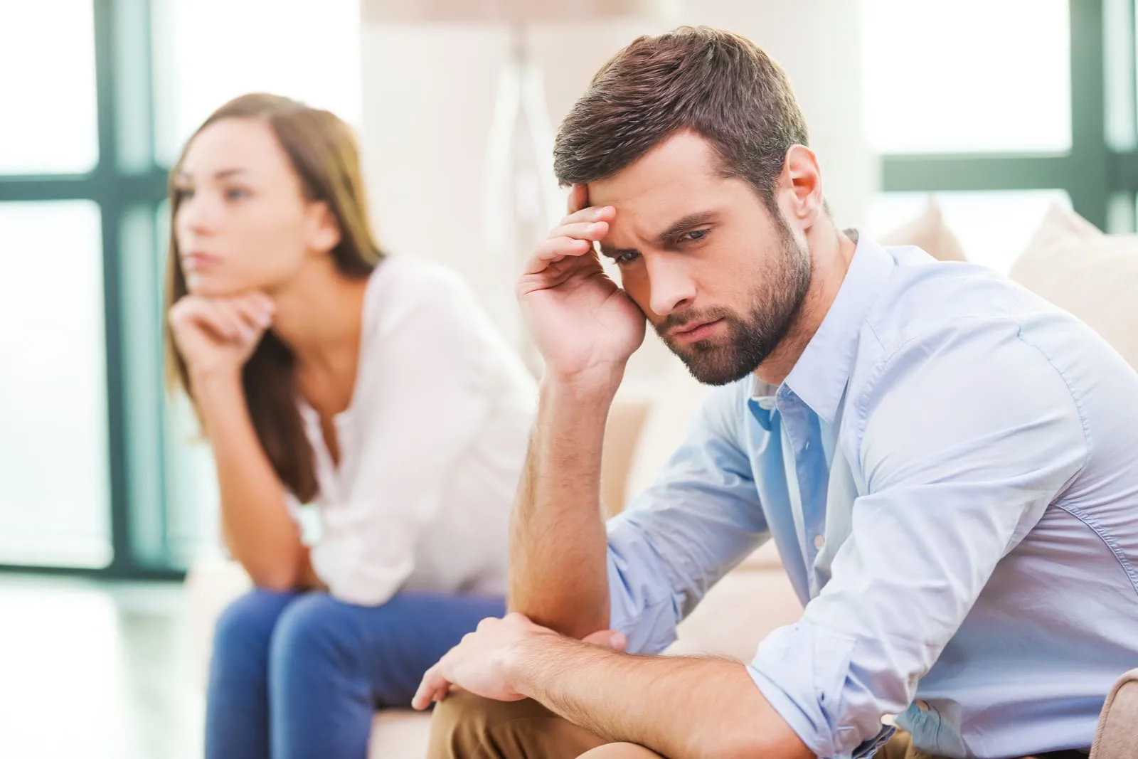 a depressed loving couple sitting in the house