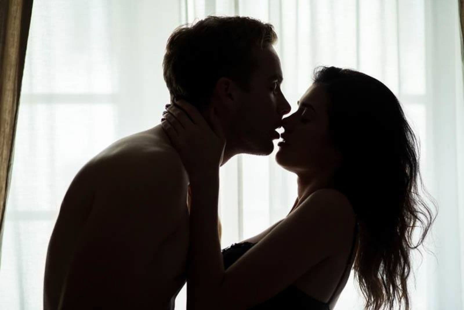 un uomo e una donna seminudi che si baciano