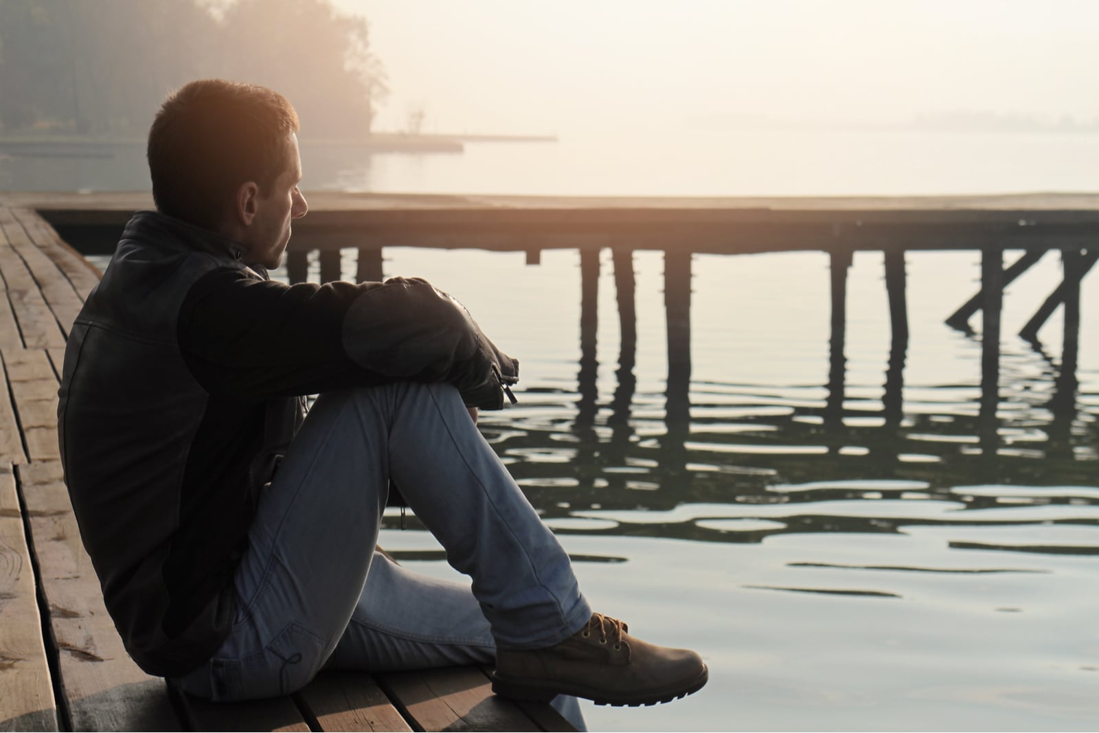 Ein Mann sitzt auf einem alten hölzernen Dock