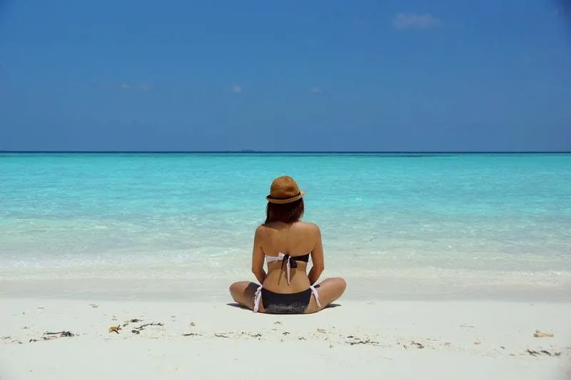 back view of woman sitting on the beach