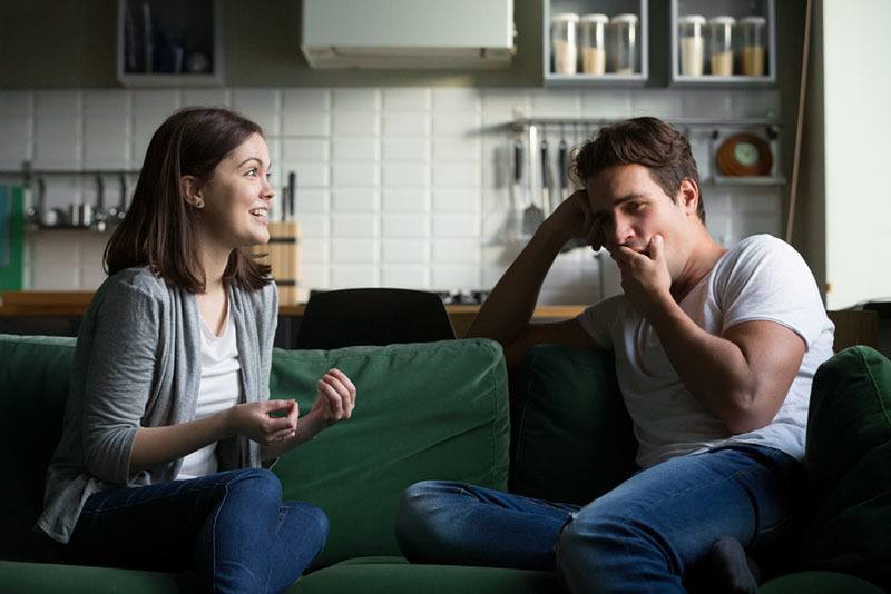 hombre aburrido escuchando hablar a una mujer