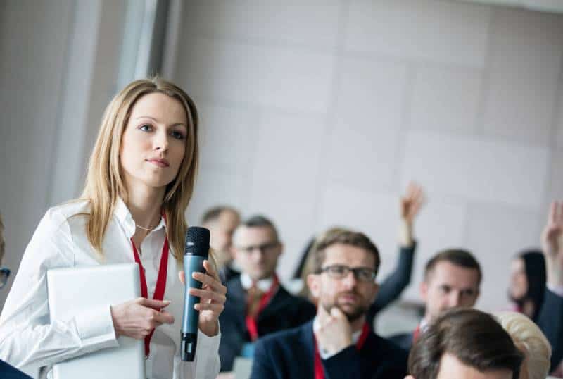 business woman holding microphone while asking questions