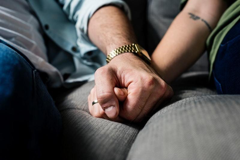 couple holding hands on the couch