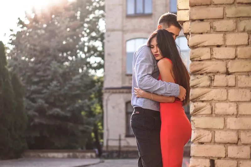 couple hugging by the wall outdoor
