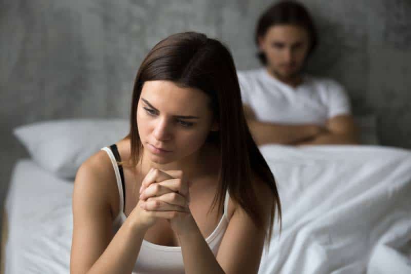frustrated girl sit on bed and thinking of relationship problem