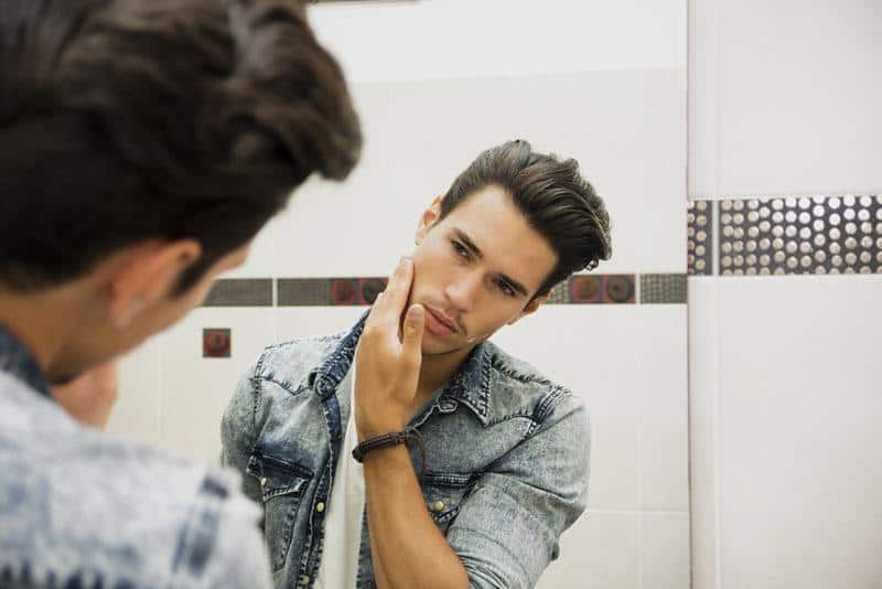 handsome man looking at mirror