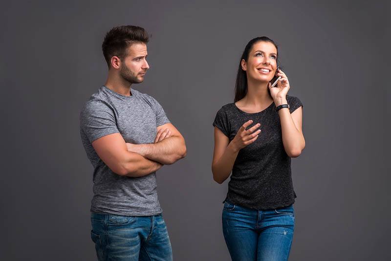 jealous man looking at woman while she having a call