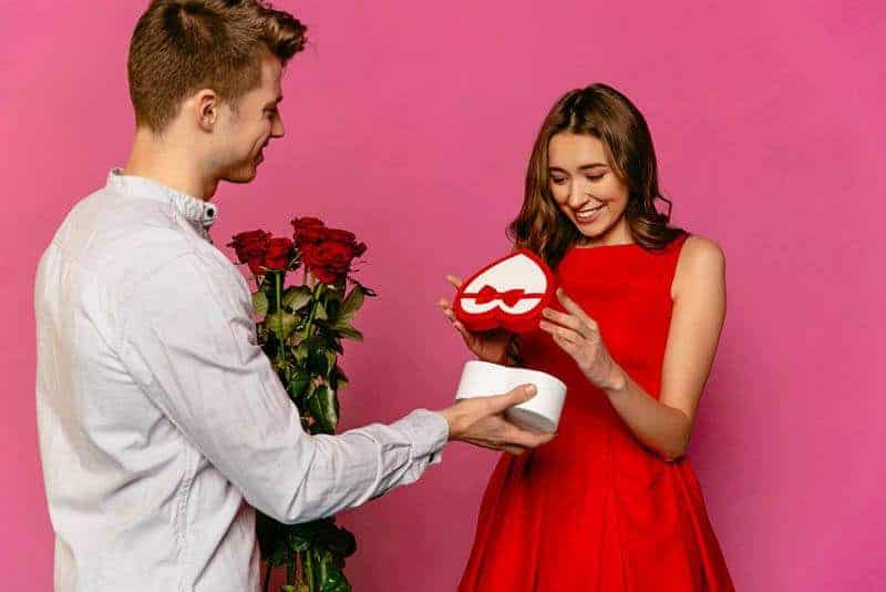man giving gift to his smiling girlfriend