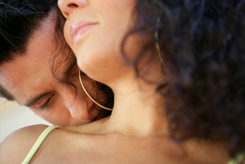 homem a beijar mulher no pescoço