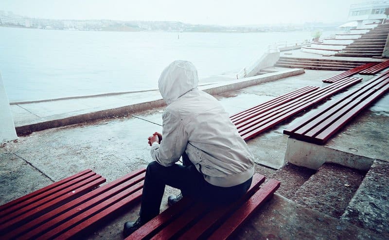 sad man sitting alone outdoor