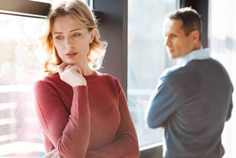 sad unhappy cheerless woman standing near her boyfriend