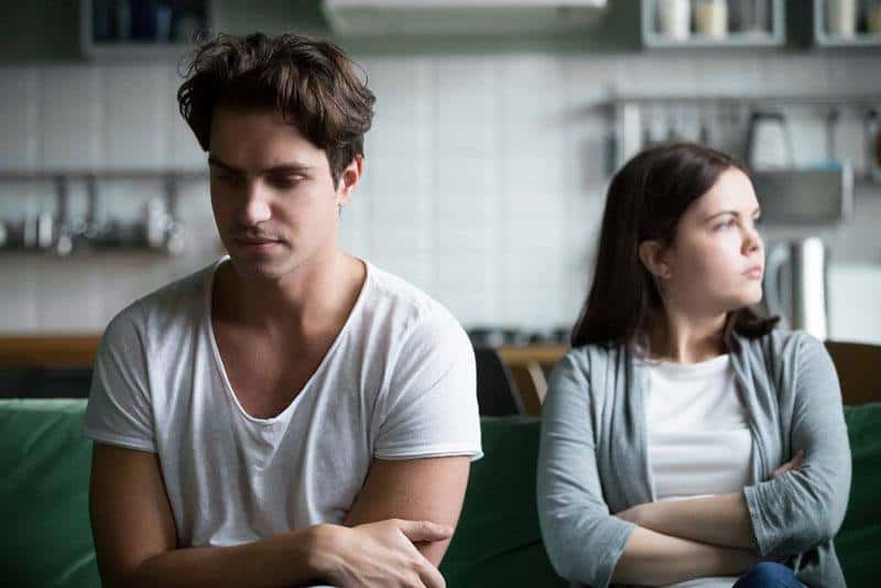 unhappy couple sitting on the couch