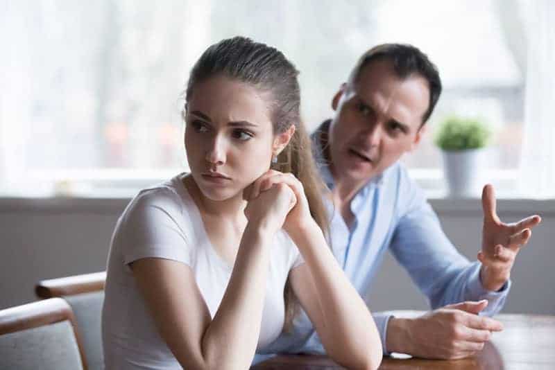 woman sitting back to lover looking away avoiding talking