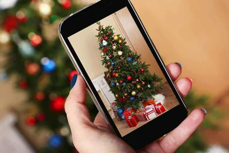 woman taking picture of christmas tree