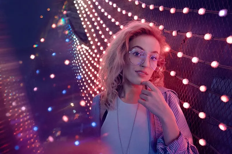 woman with glasses standing by the lights