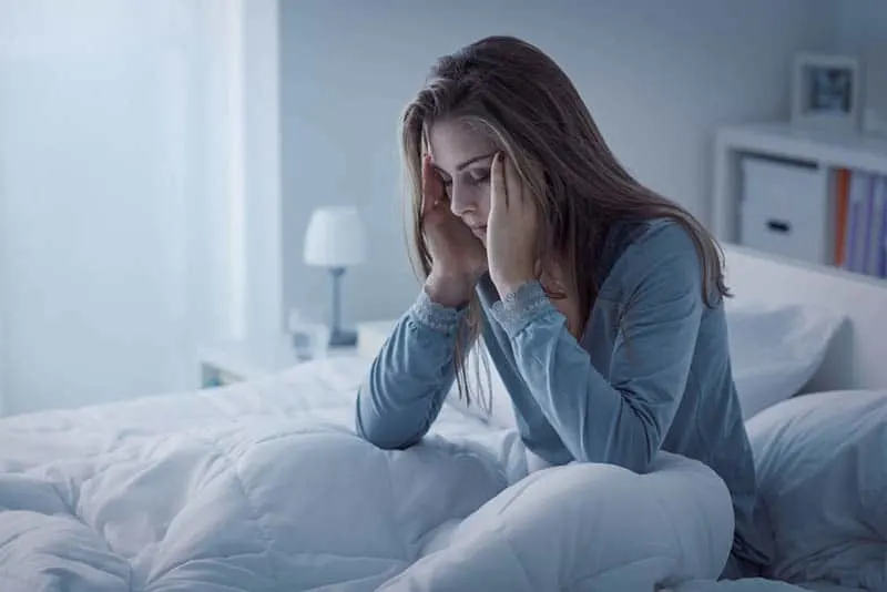 worried woman sitting on bed