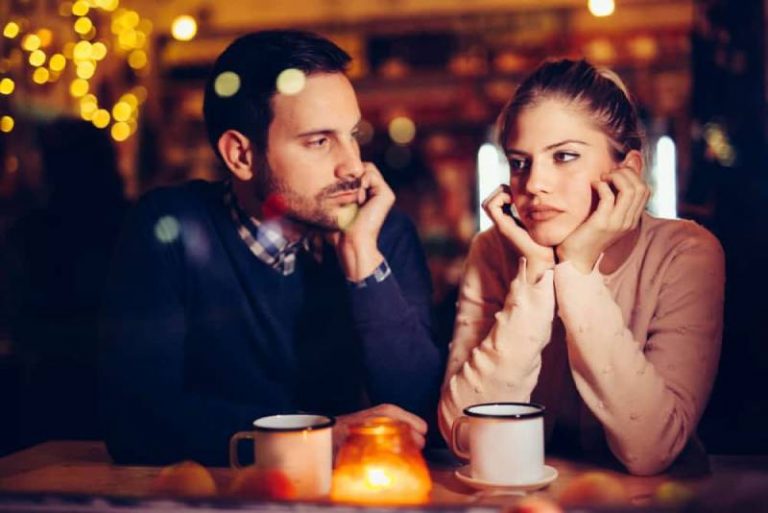 man looking at thoughtful woman in cafe