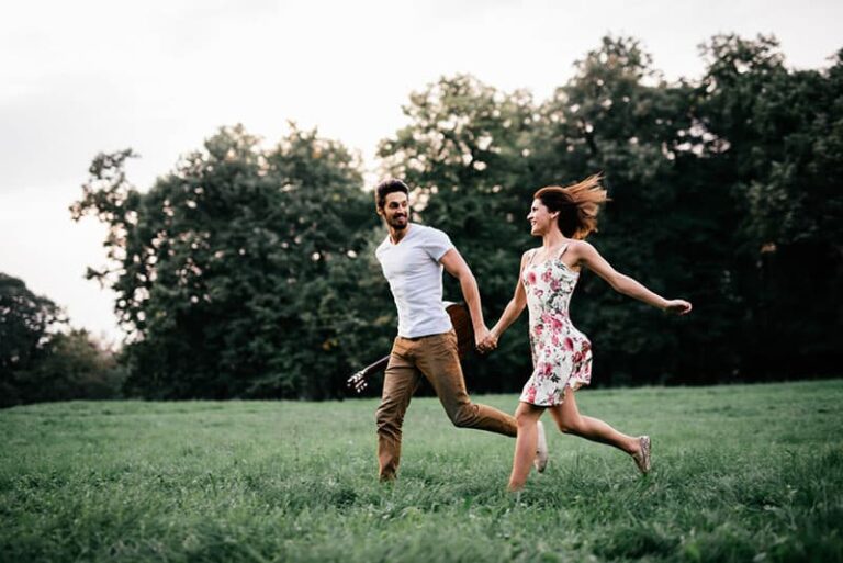 happy couple running on the grass