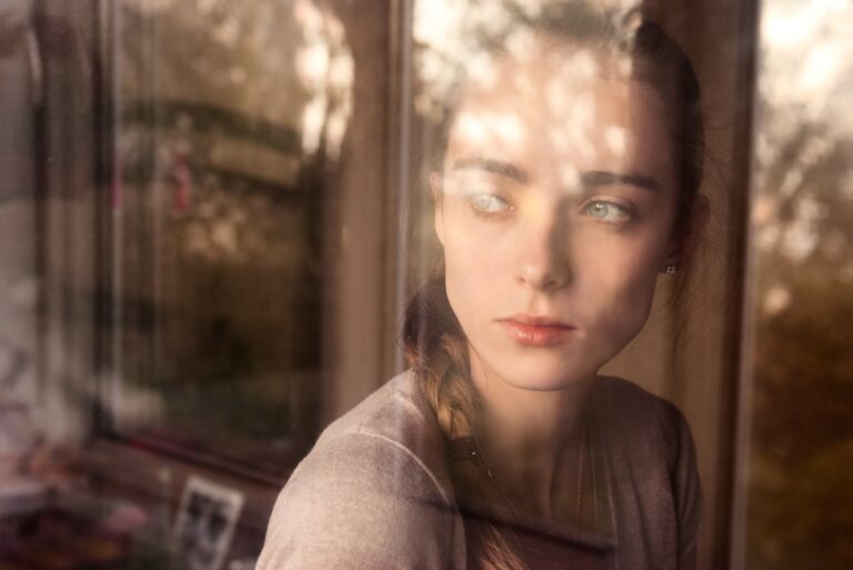 una mujer triste mira por la ventana