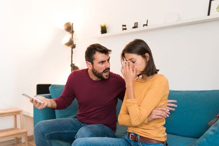 man yelling at woman on the couch