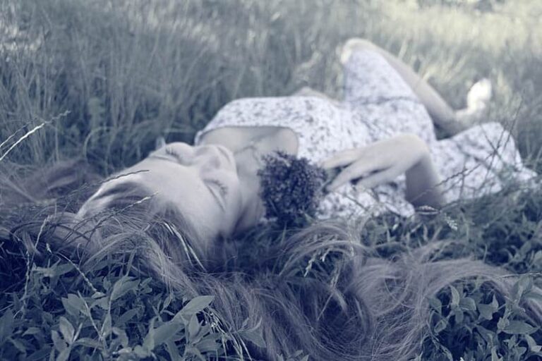 the woman is lying in the grass
