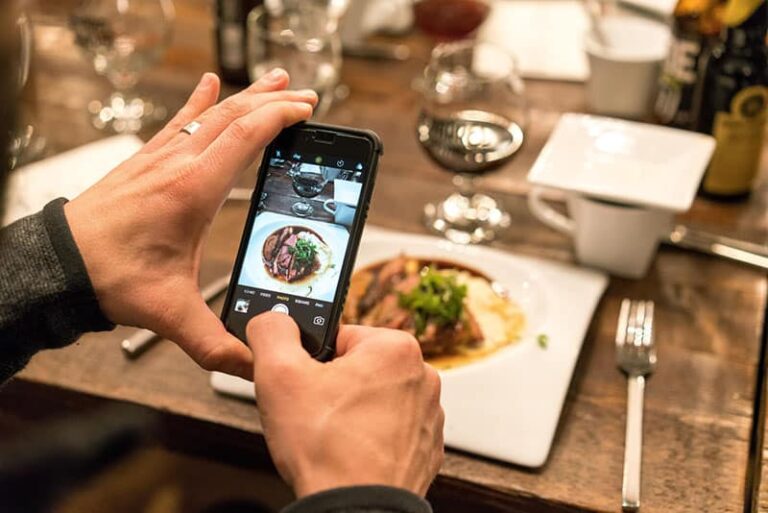 man taking picture of dinner