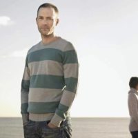 man wearing sweatshirt standing against the woman